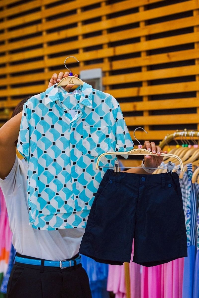 Light blue patterned short-sleeve shirt and navy shorts for boys on hangers