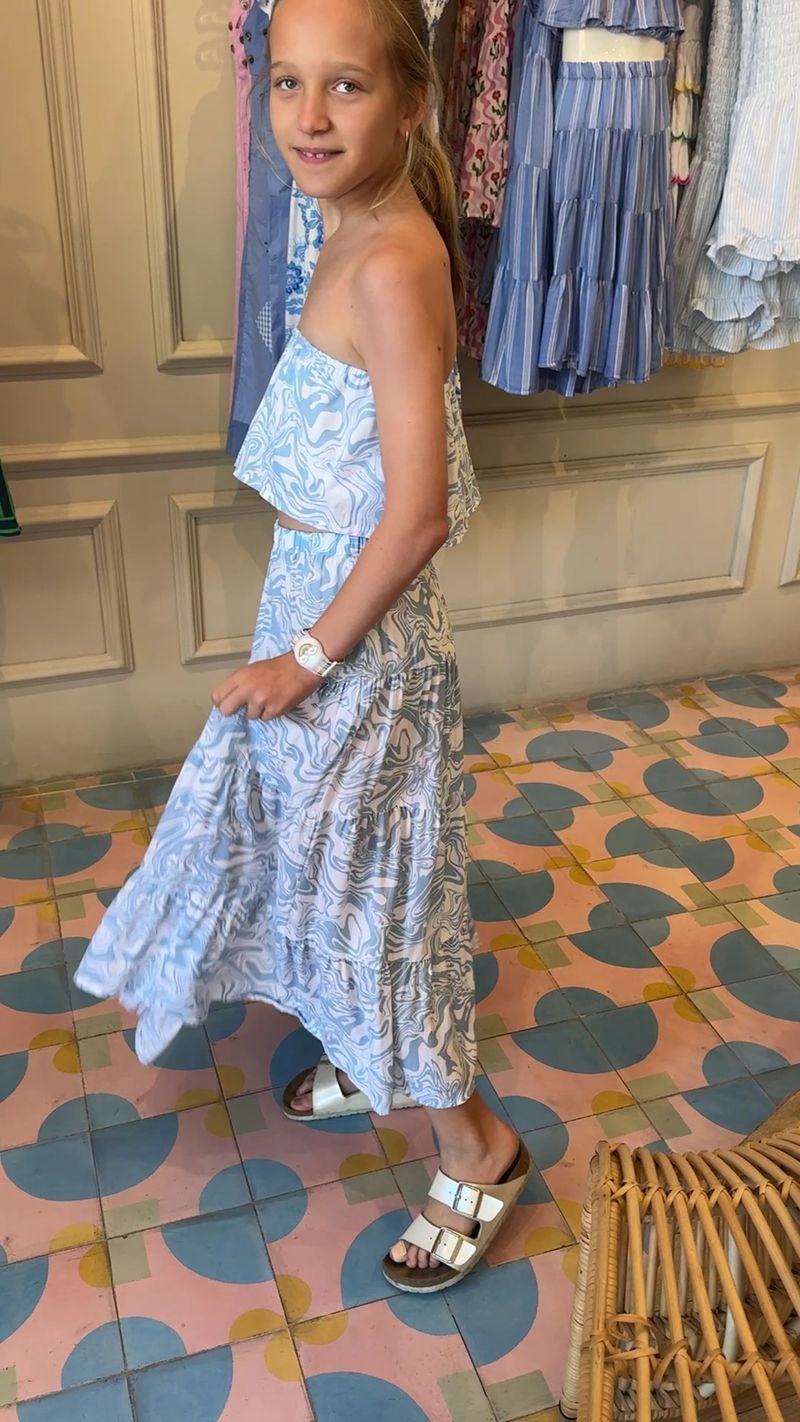Girl in a light blue and white patterned summer dress in the shop